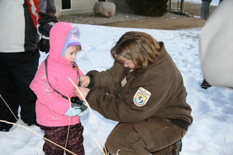 a person kneeling down in the snow with a child