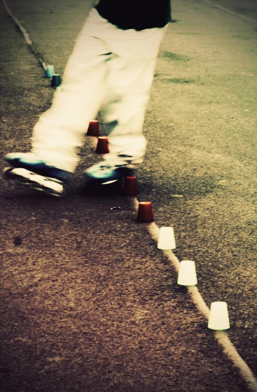 a man riding on top of a skateboard down a street