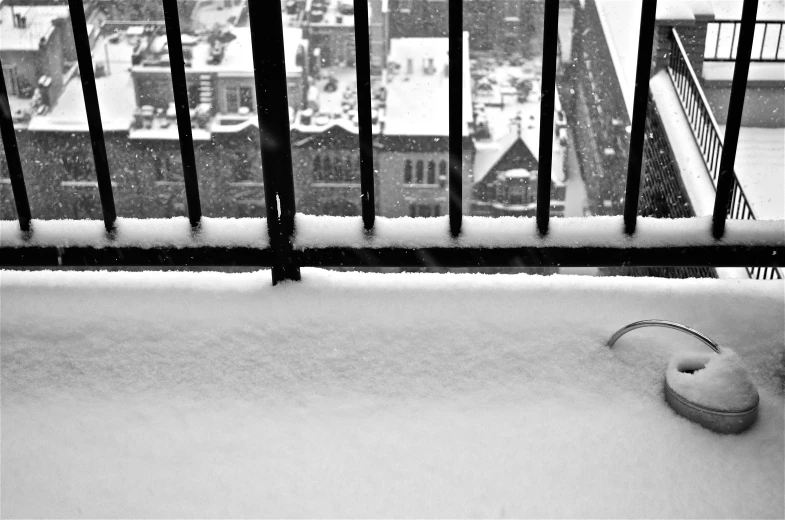 a snow covered bench with a street sign, street light and a fence