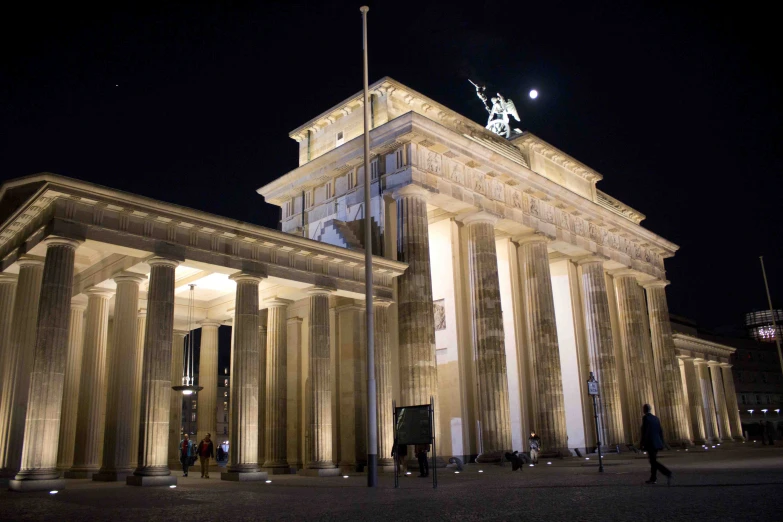 a tall building with pillars and lights on it