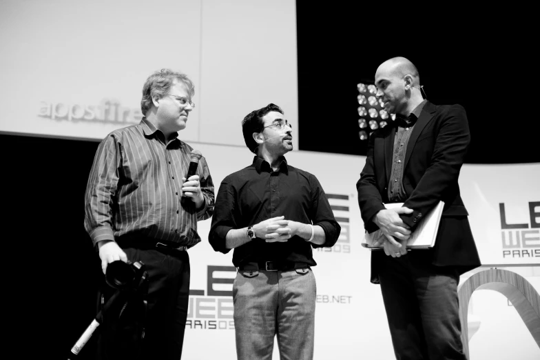 a few men standing on stage talking