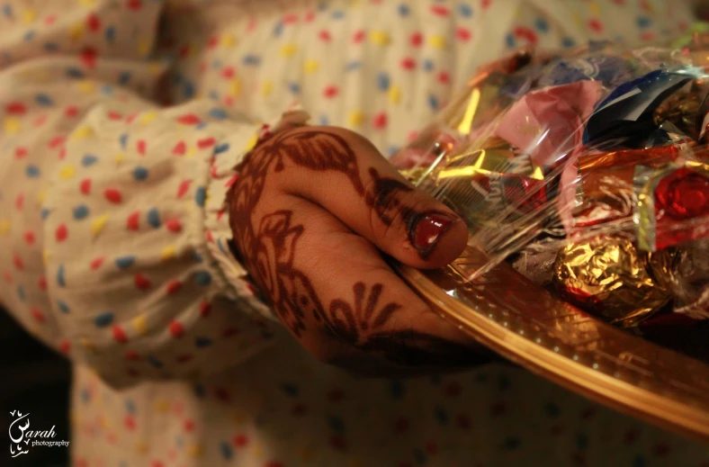 a woman holding a tray of candy and candies