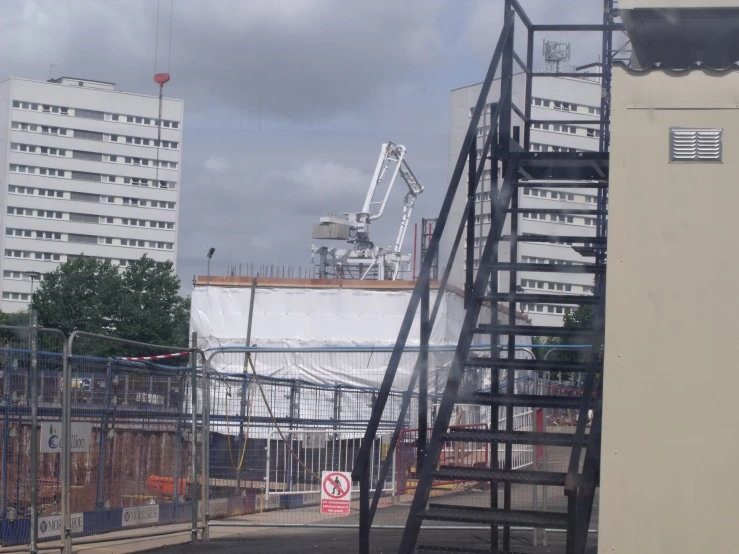 a crane stands on top of a building and another crane is next to it