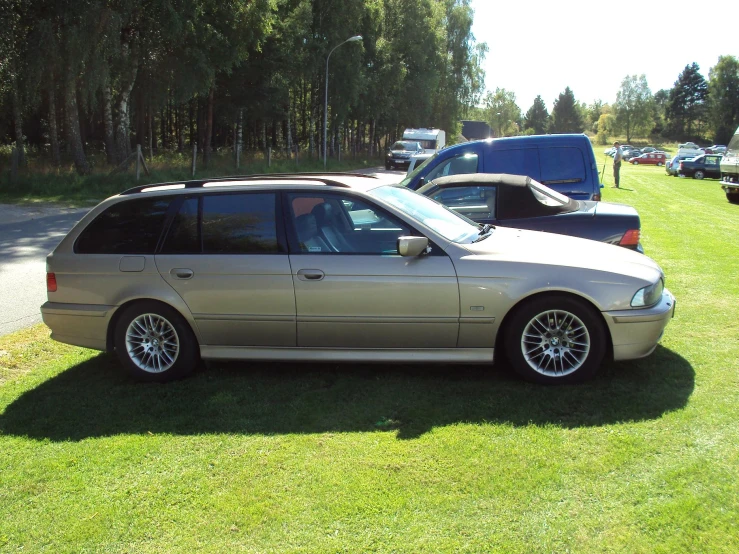 a golden bmw parked next to other cars