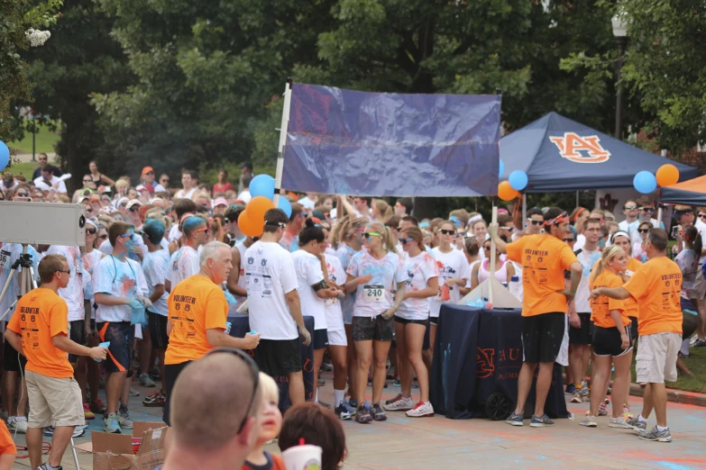 a crowd of people who are holding blue and orange balloons