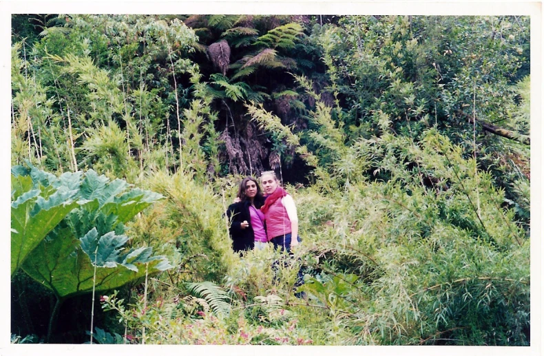 two women are standing in tall grass together