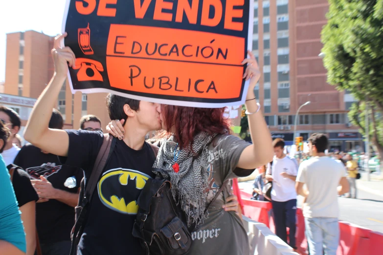 the two people are kissing under a sign