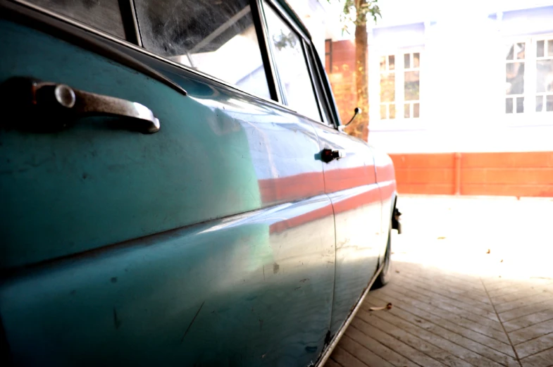 an old car parked on the side of a sidewalk