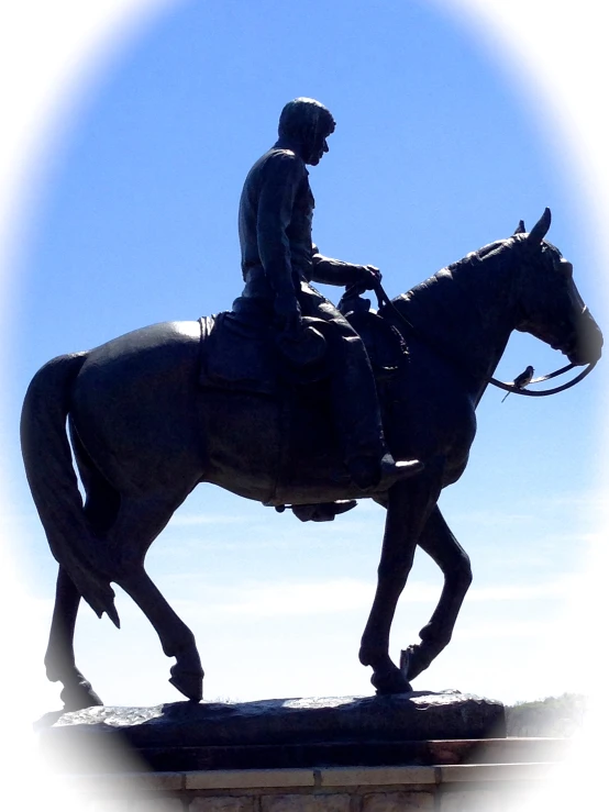 statue in the shape of a man on horse back with sky in background