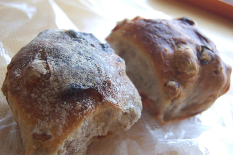 two muffins on a piece of plastic with wax paper