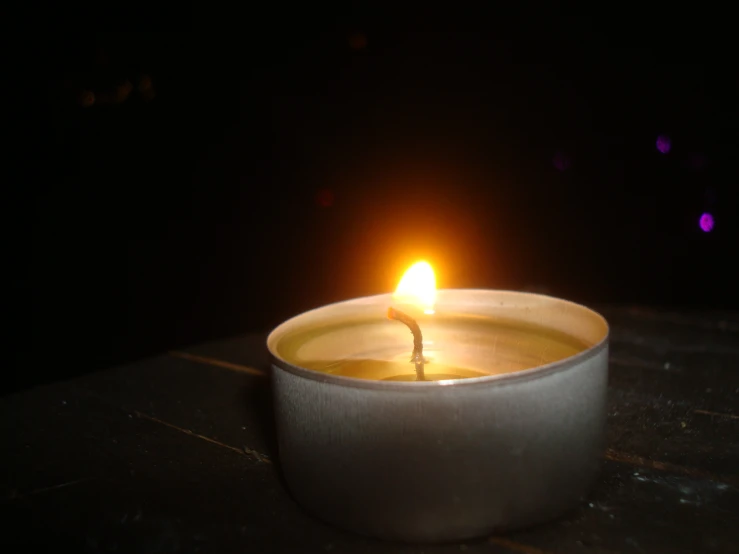 a lit candle on a black background