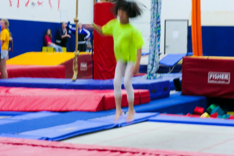 a person jumping on a trampoline in an indoor gym