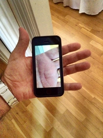 person holding up small mobile device that is turned off