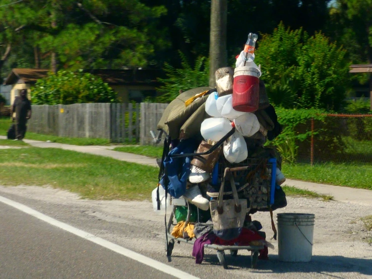 an old man is pulling some luggage down the road