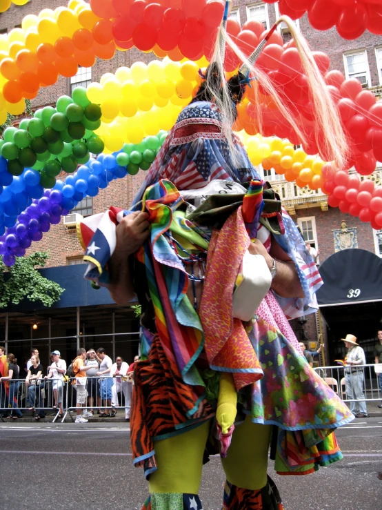 a man with lots of colorfully dressed clothing on, walking