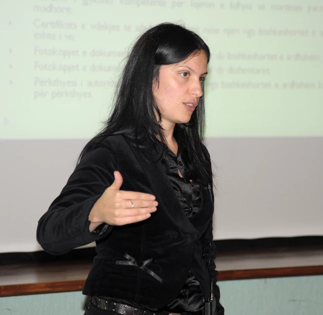 a woman giving a lecture while standing in front of a whiteboard