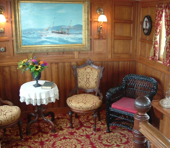 a living room with chairs and a table with flowers