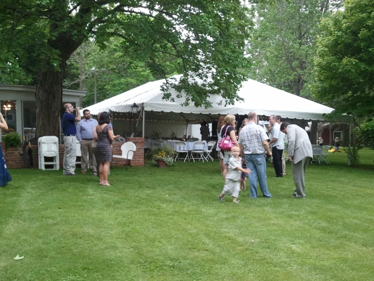 several people are at a tent where one person is holding a child