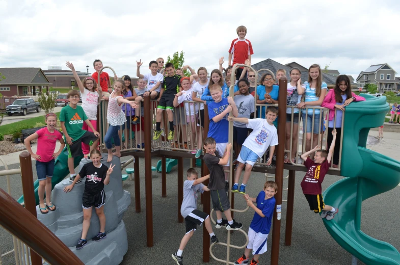 children are playing on a wooden play structure