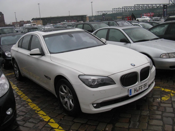 a white car in a parking lot near other cars