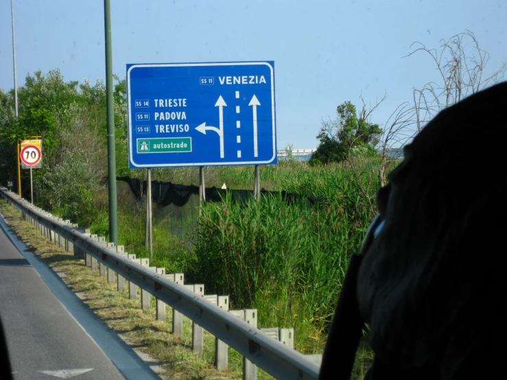 a blue road sign is on the side of the road