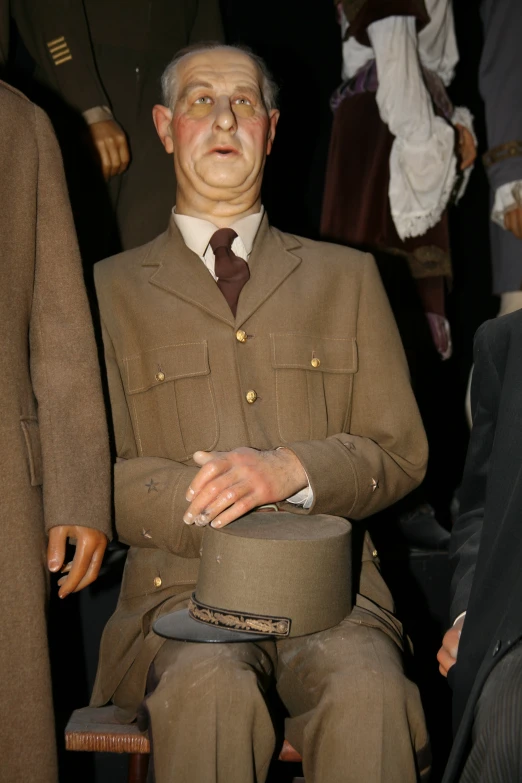 a large man in a brown uniform sitting in front of several other people