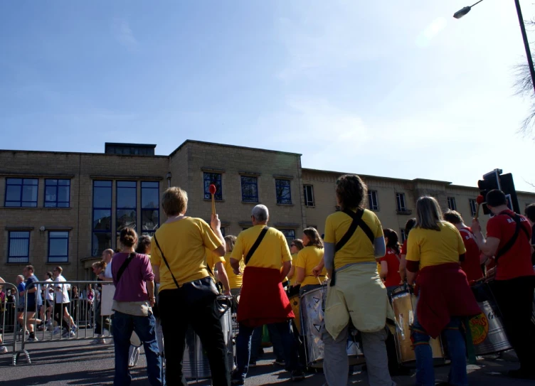 there are people walking along the street wearing orange and yellow