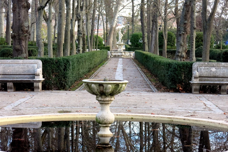 two cement benches sitting next to a fountain