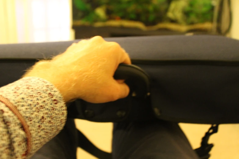 the back end of a chair holding a black object