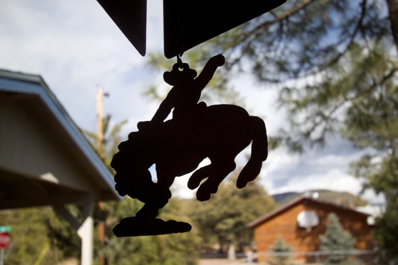 silhouette of man hanging on a wind vane