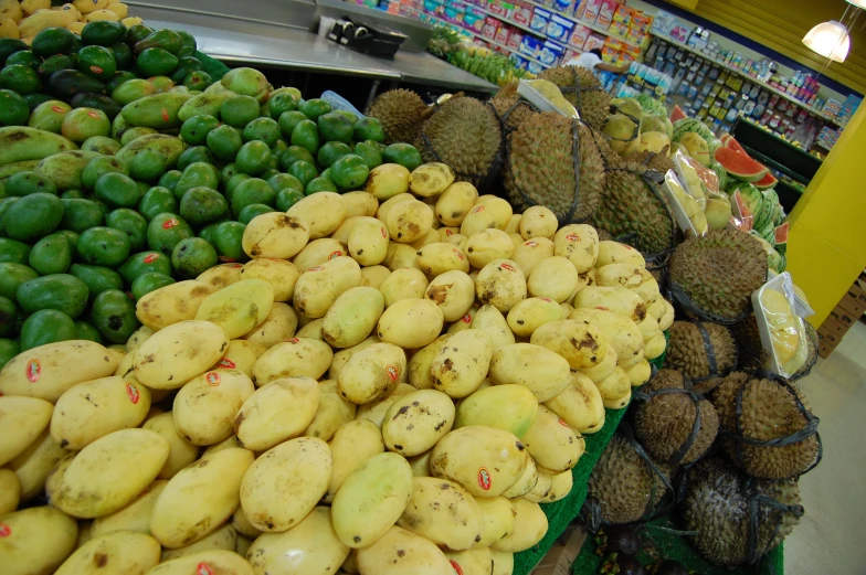 fresh fruit at a grocery store filled with mangoes and avocados