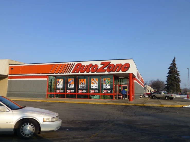 a car sitting outside of a store with two men in the street