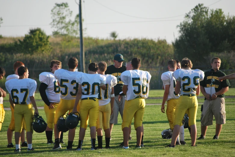 football players are huddled on the sideline talking