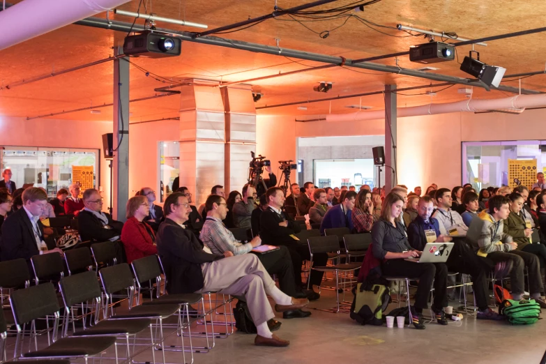 audience gathered in a room for a seminar on stage