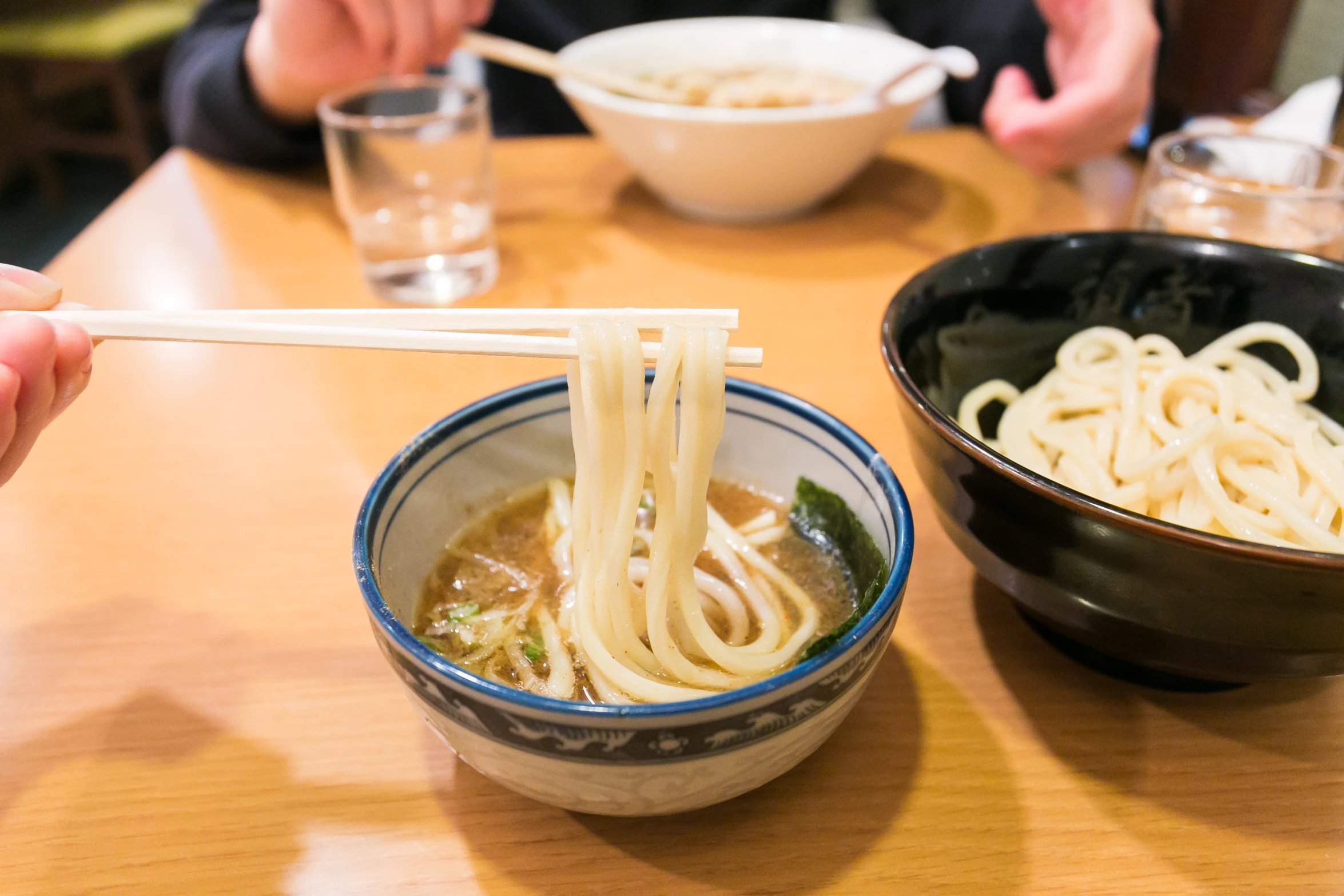 a person sitting at a table with bowls and bowls of food