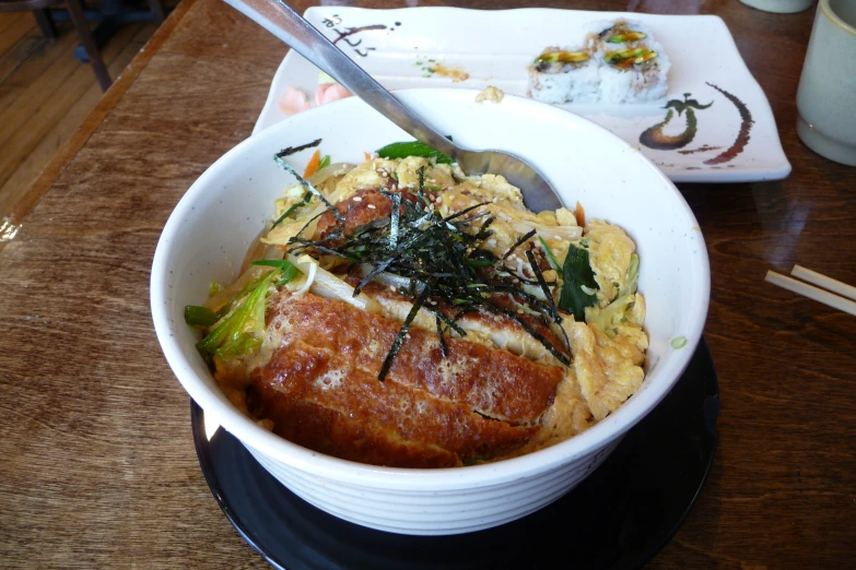 a white bowl of food sitting on top of a table