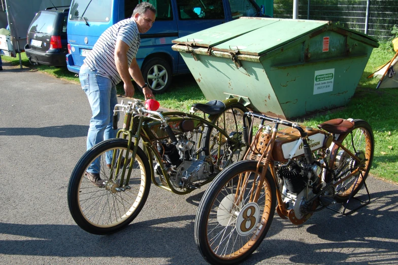 an older man looking over some antique bicycles