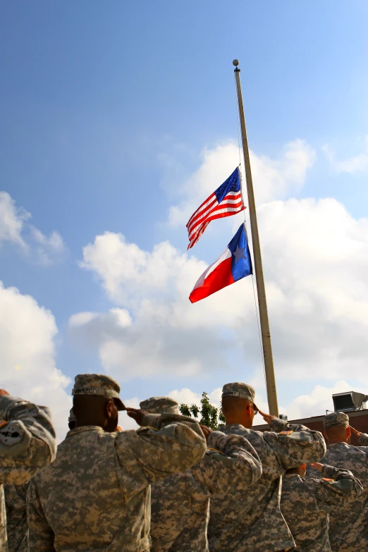 a large group of men standing in front of a flag