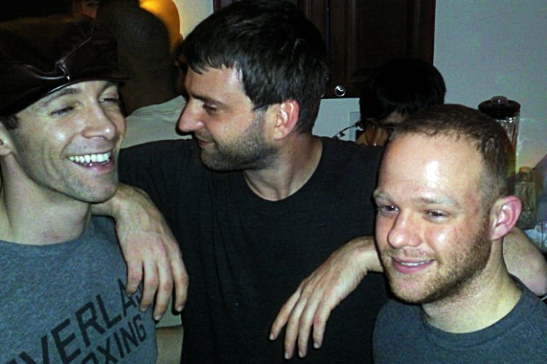 three men are smiling and having a good time together
