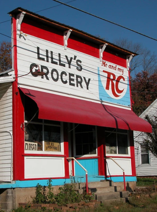 a red and white grocery store with red awnings