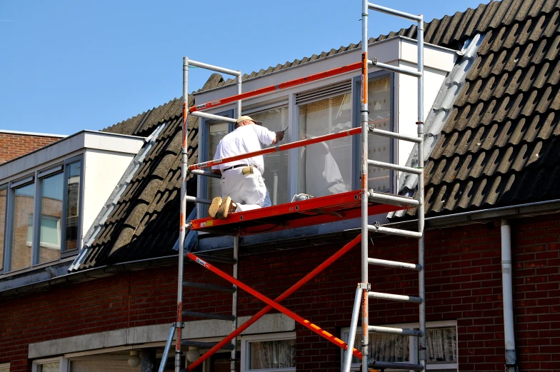 a man is hanging up the windows of his house