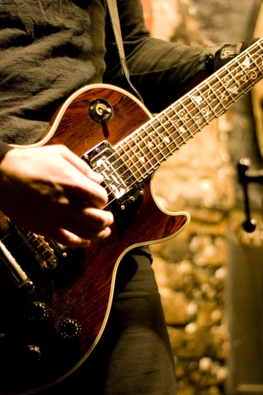 a person holding an electric guitar near a wall