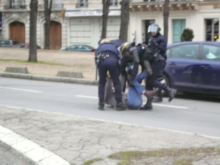 a group of men are surrounding a person on the street