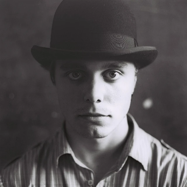 a man wearing a striped shirt and a bowler hat