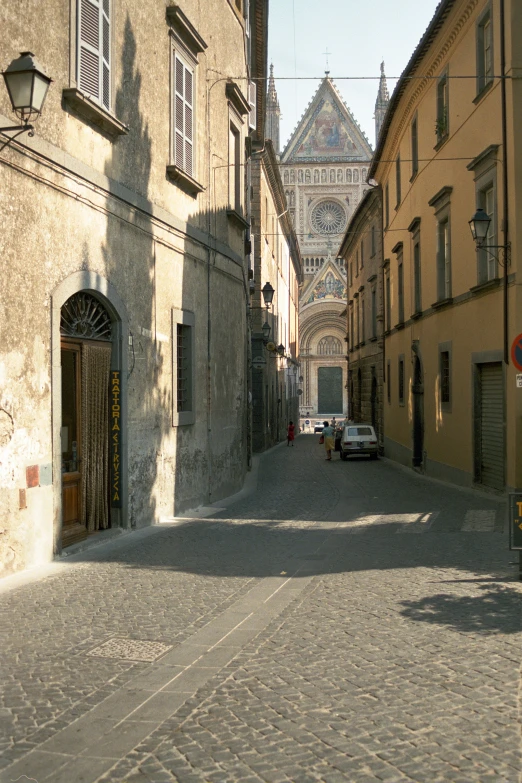 a narrow street is shown with a cobble stone road