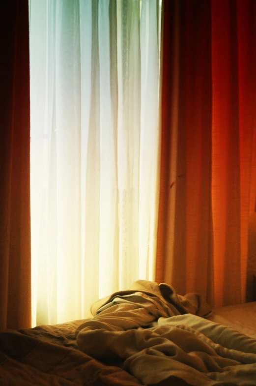 a bedroom with large windows and sheer curtains