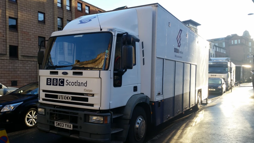 a white truck driving on the side of a street