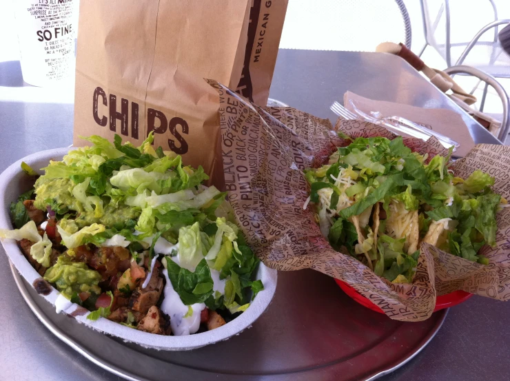 two paper bags on the table with food