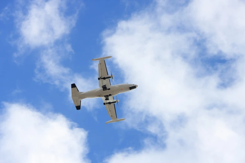 a plane flying in the sky on a cloudy day