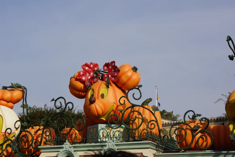 a large balloon on top of an ornate iron fence with pumpkins for decoration